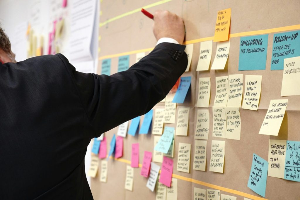 Person hanging sticky notes on board